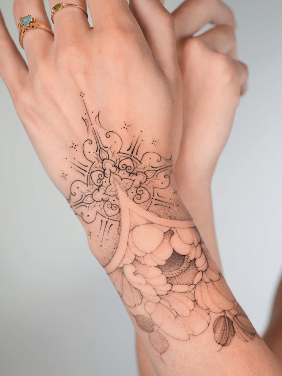 magnifique tatouage sur le poignet mélangeant une pivoine, fleur très fine te de l'ornemental