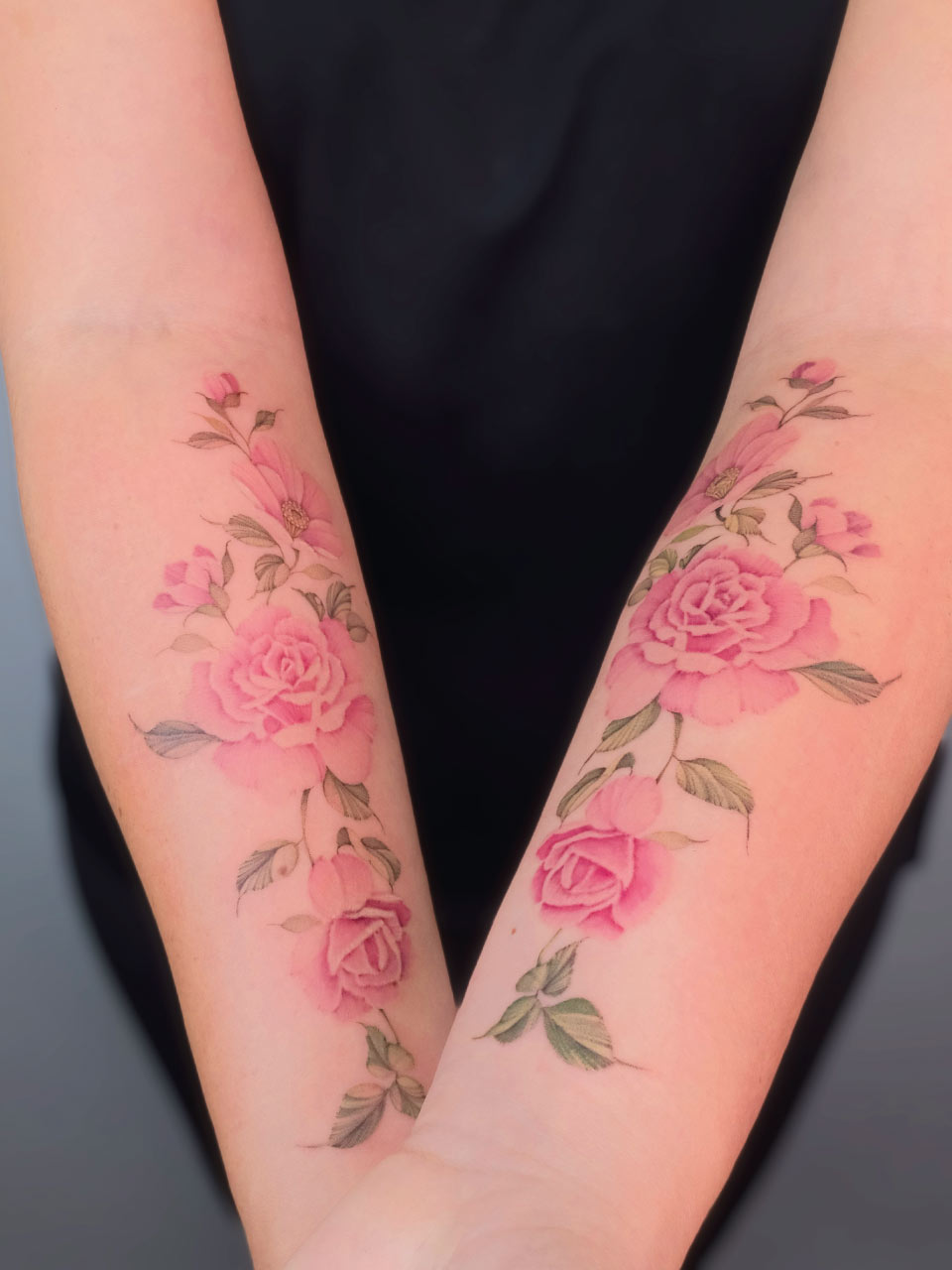 tatouage en symétrie sur les avant bras représentant des fleurs en couleur très fine