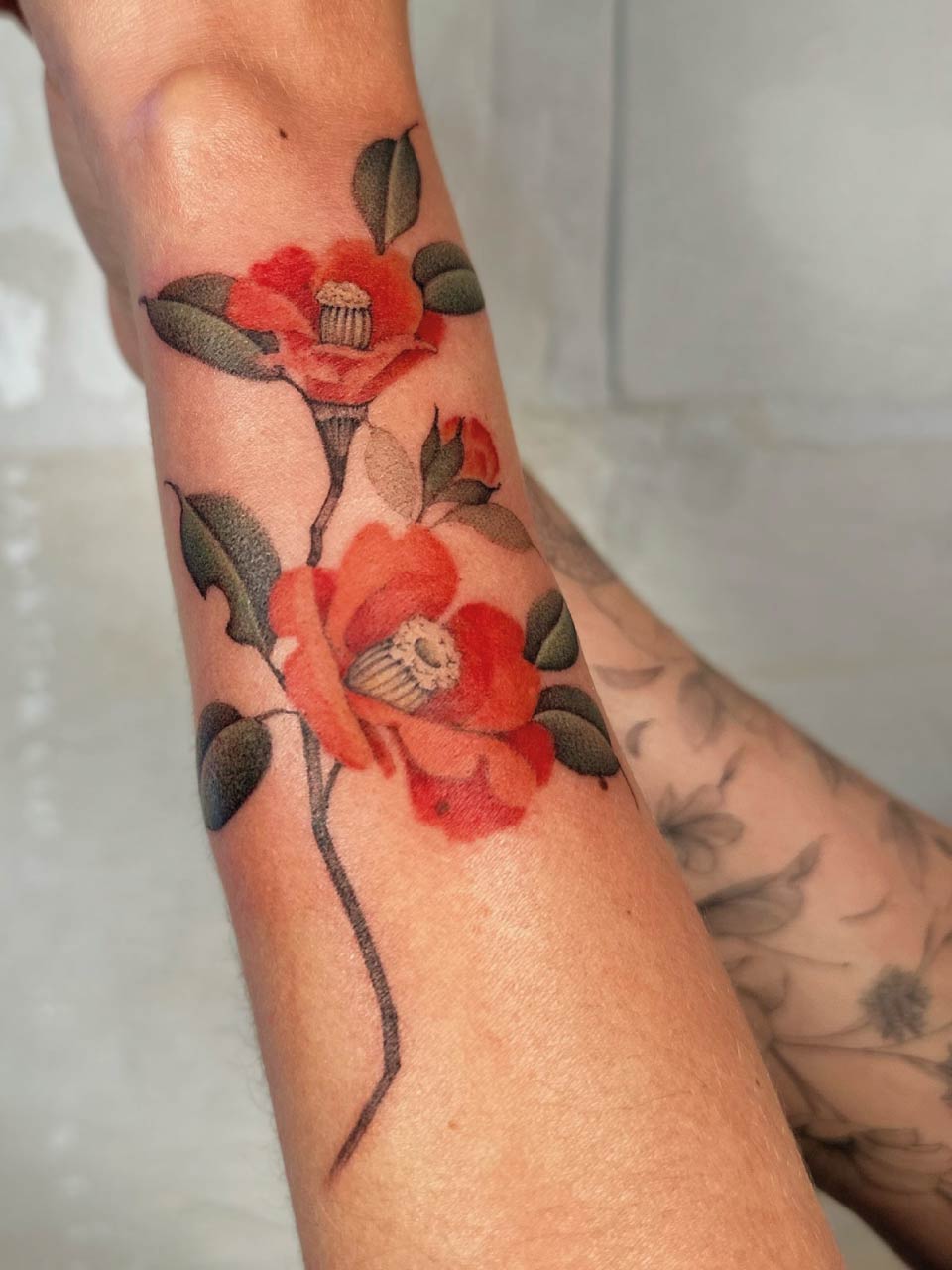 tatouage de fleurs en couleurs sur l'avant bras. Très fin