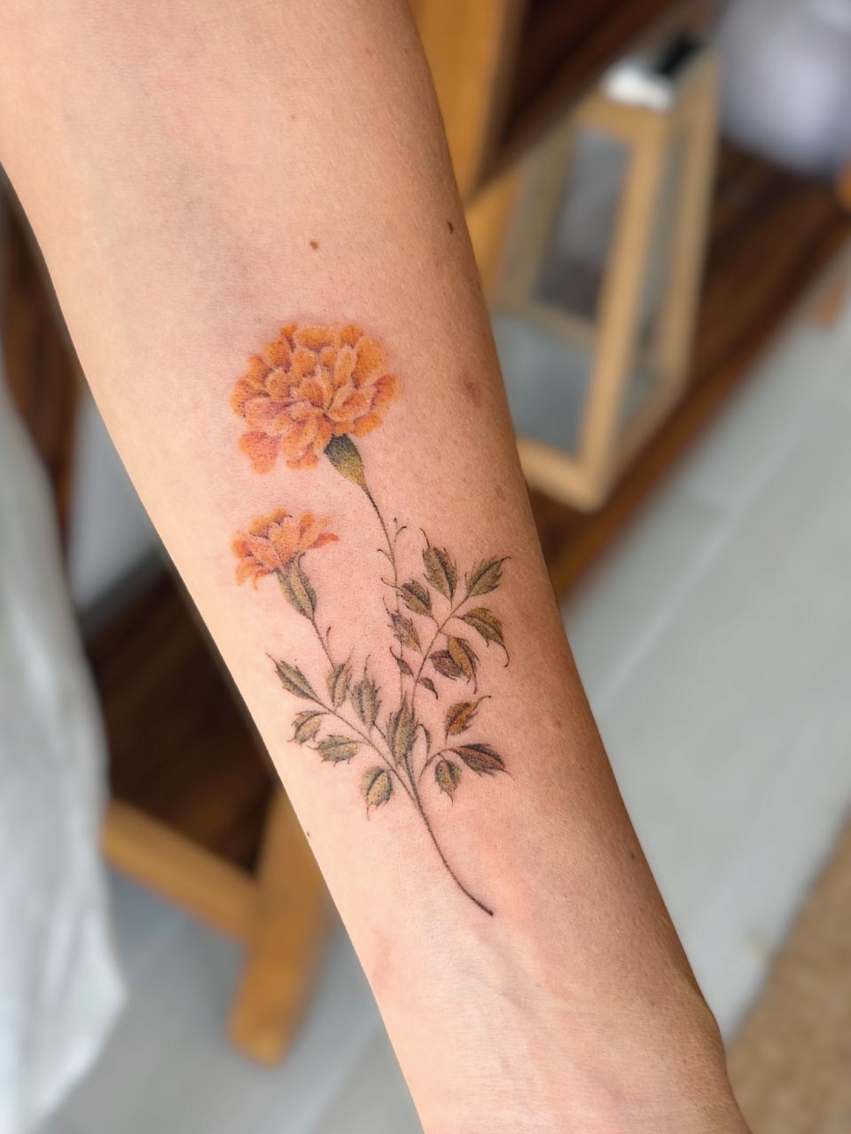 tatouage d'une fleur en couleur, fine et délicate sur l'avant bras